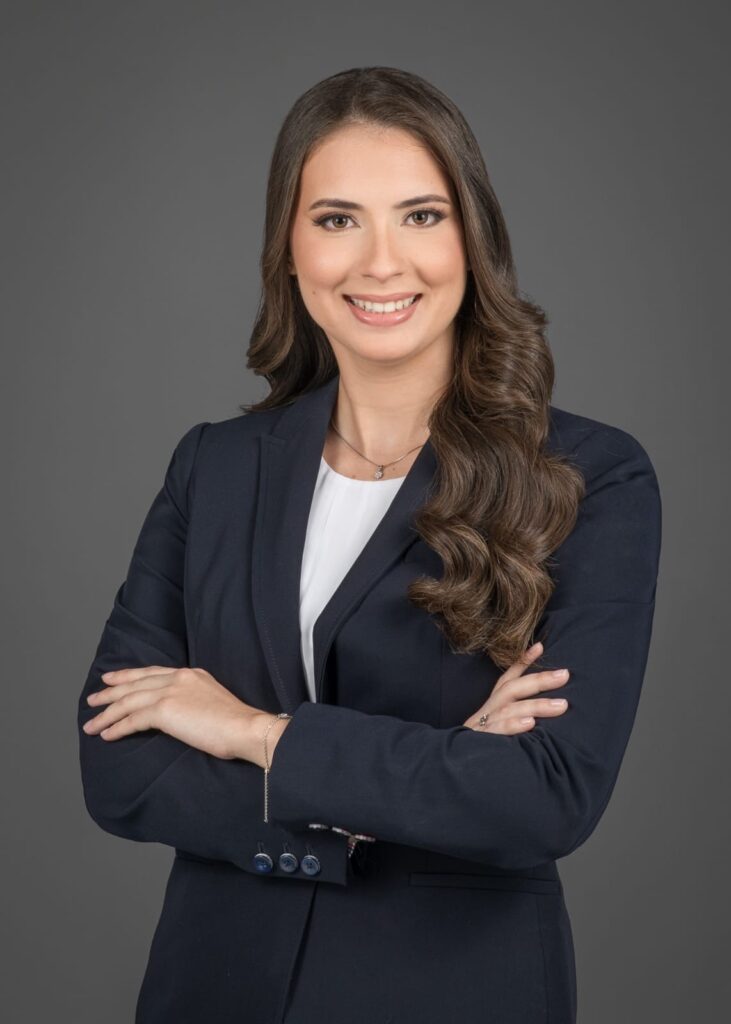 Danet Lugo stands with crossed arms in a suit.