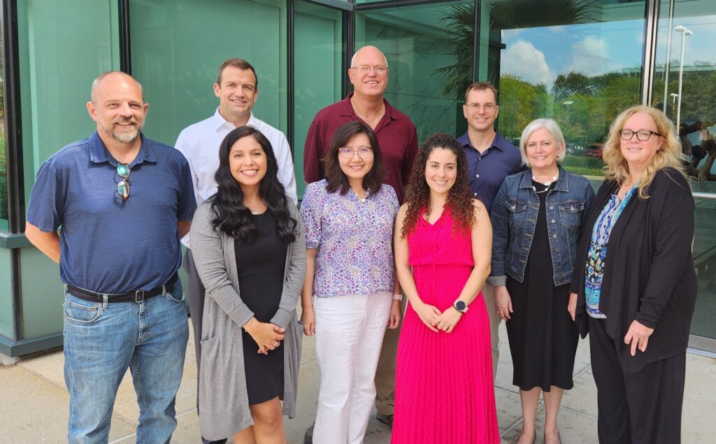 Nine members of the ABR Diagnostic Radiology Core MSK Committee pose outside a building.