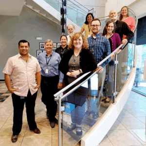 Ten committee members pose on a stairway.